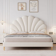 Beige shell-patterned bed in a bedroom setting with framed artwork on the wall.
